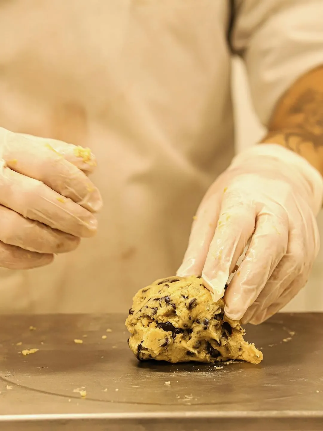 Mathieu façonne une boule de pâte à cookie aux pépites de chocolat dans l'atelier